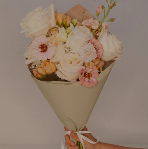 Large wrapped flower bouquet with pink tones from Verbena Floral Design.