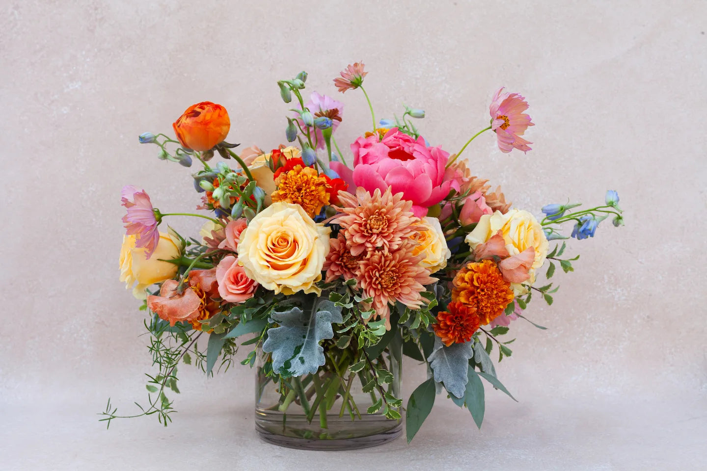 Lush garden floral arrangement with colorful flowers in a glass vase.