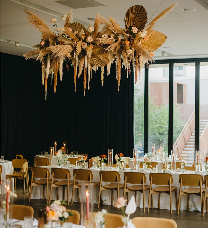 Fall wedding with orange tones and a custom floral arrangement on the ceiling.